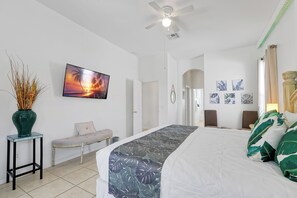 A bedroom with a bed, a television, a ceiling fan, and a wall-mounted artwork. - 4BR Golf Villa w/ Pool, Near Disney & Beaches (Davenport)