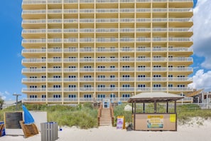 A multi-story hotel with balconies, a beachside location, and a sign for chair rentals. - Beachfront PCB Condo: Walk to the Sand! (Panama City Beach)