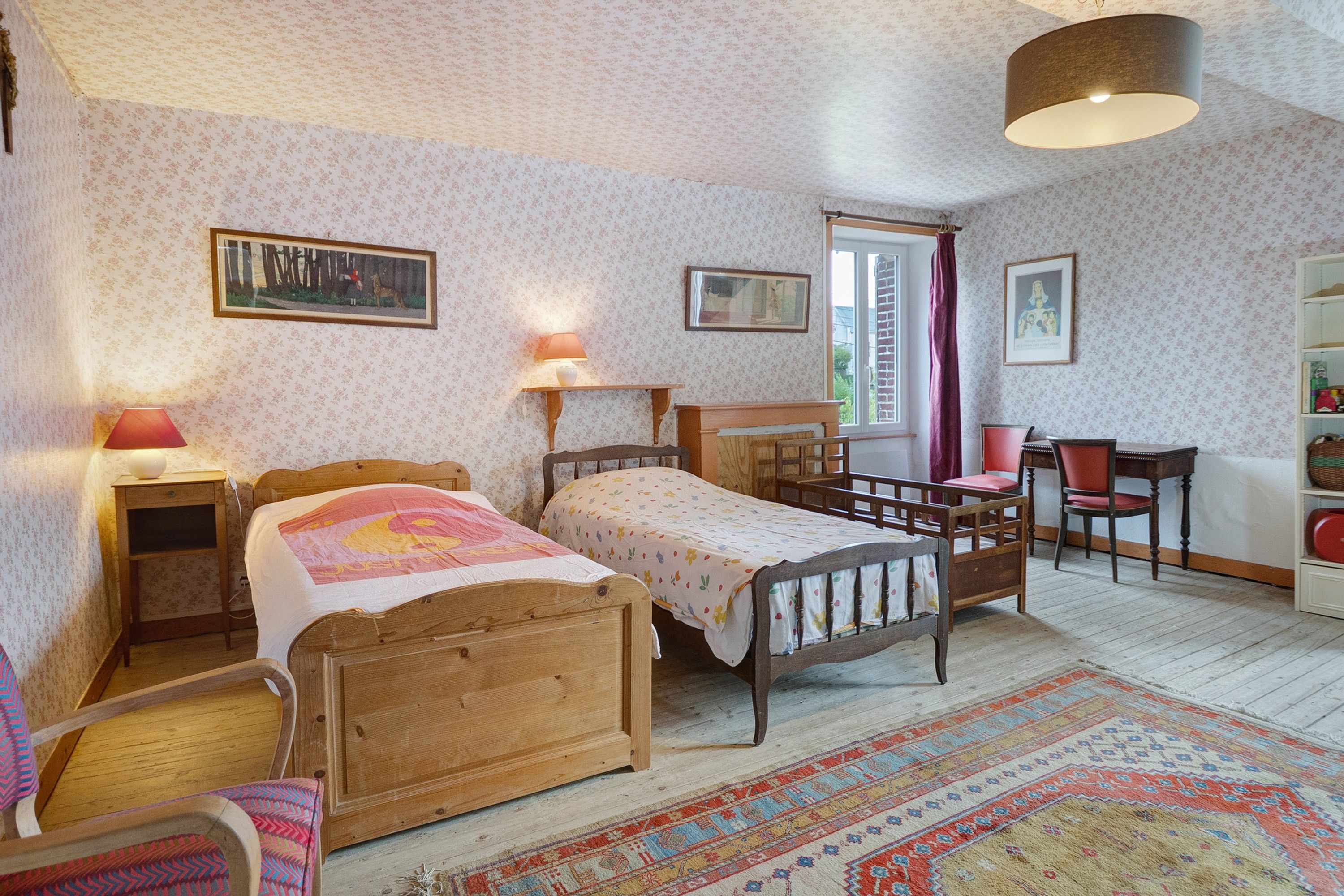 Een klassieke slaapkamer met twee houten bedden, een bureau, een stoel en een boekenkast.