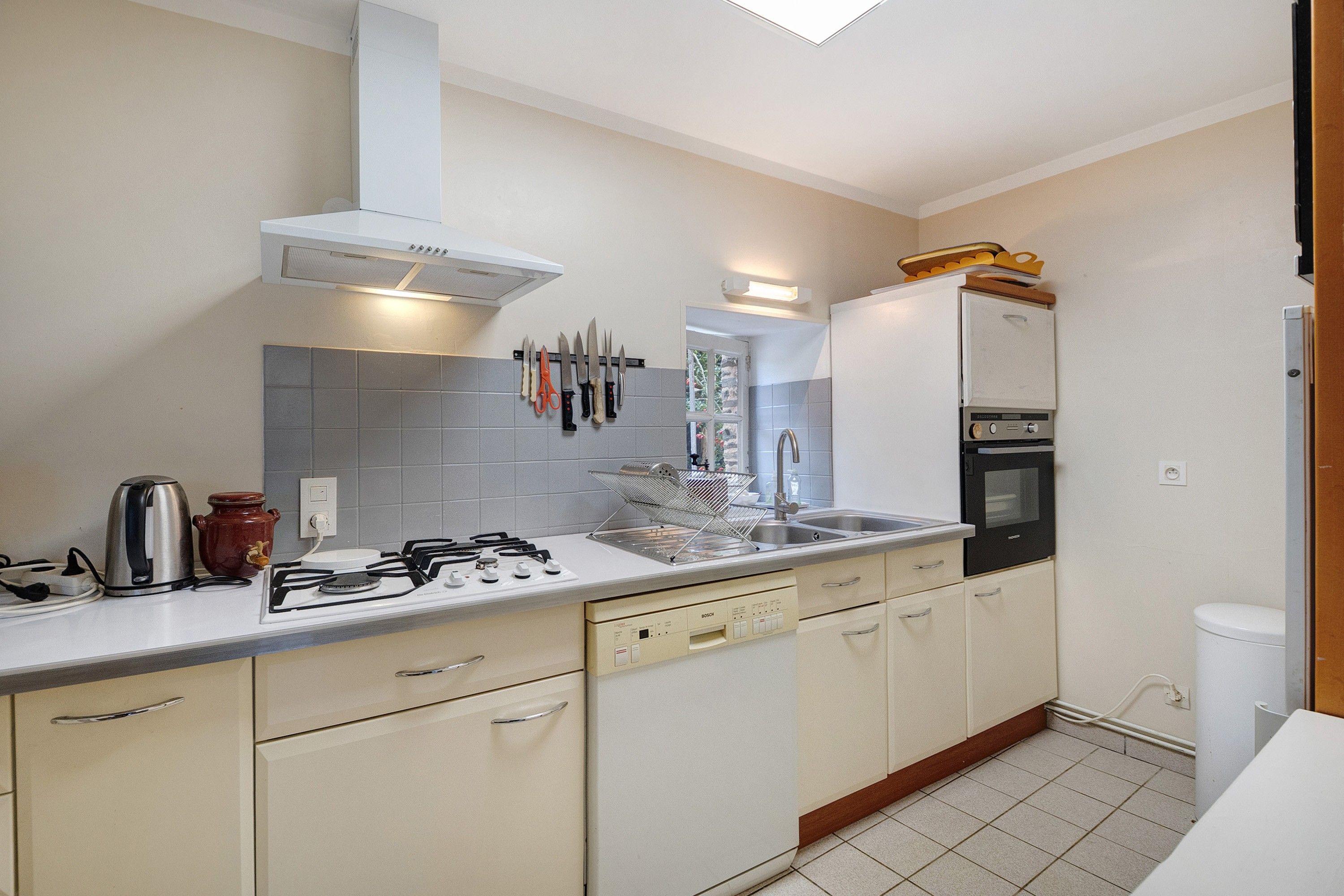 A compact kitchen with a gas stove, a built-in oven, and a sink.