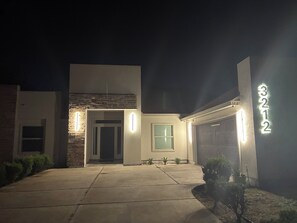 Ein modernes, zweistöckiges Haus mit Garage, Ziegel-Fassade und einer gut beleuchteten Eingangspartei.