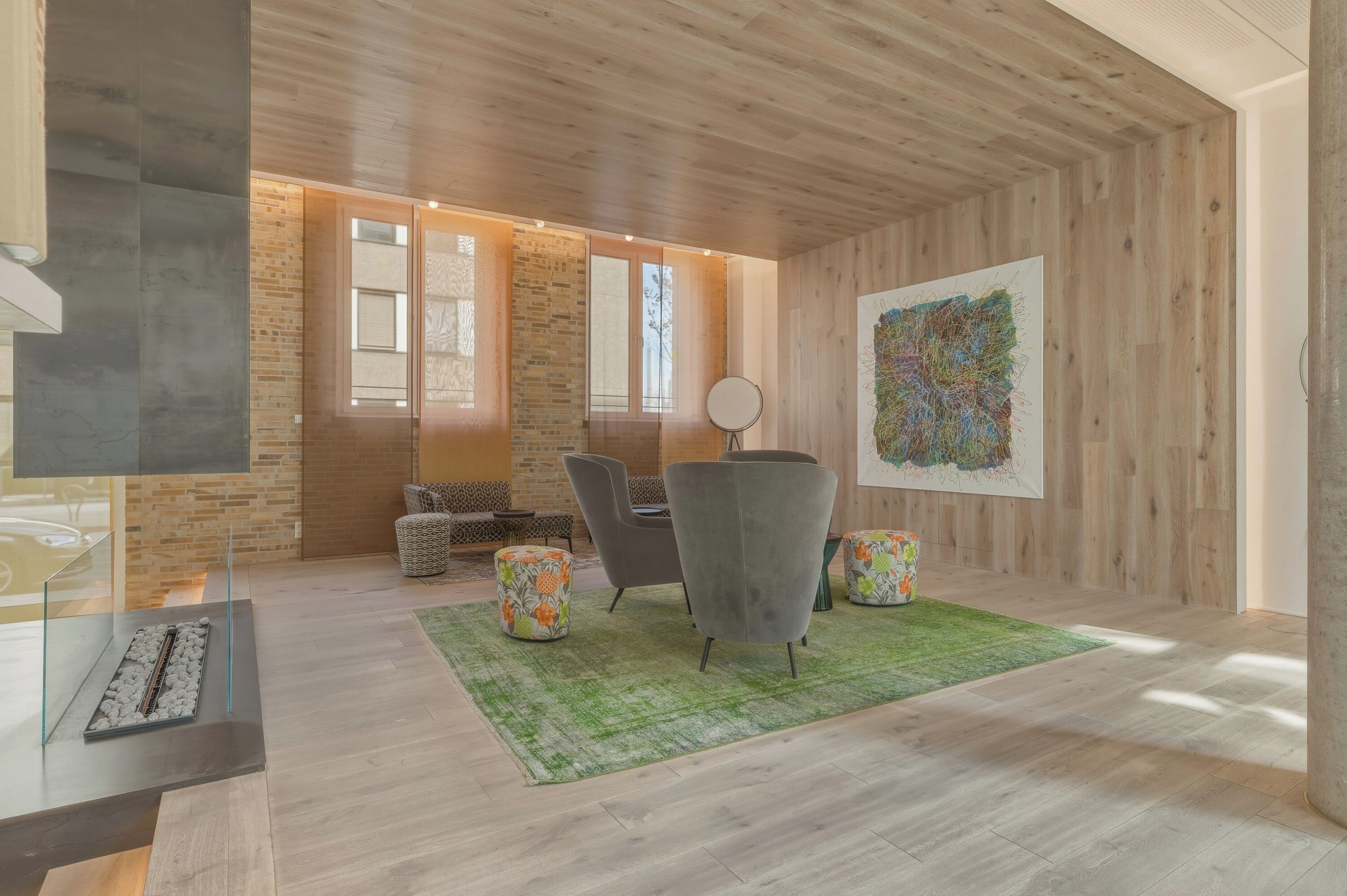 A modern living room with a fireplace, seating area, and artwork on the wall.