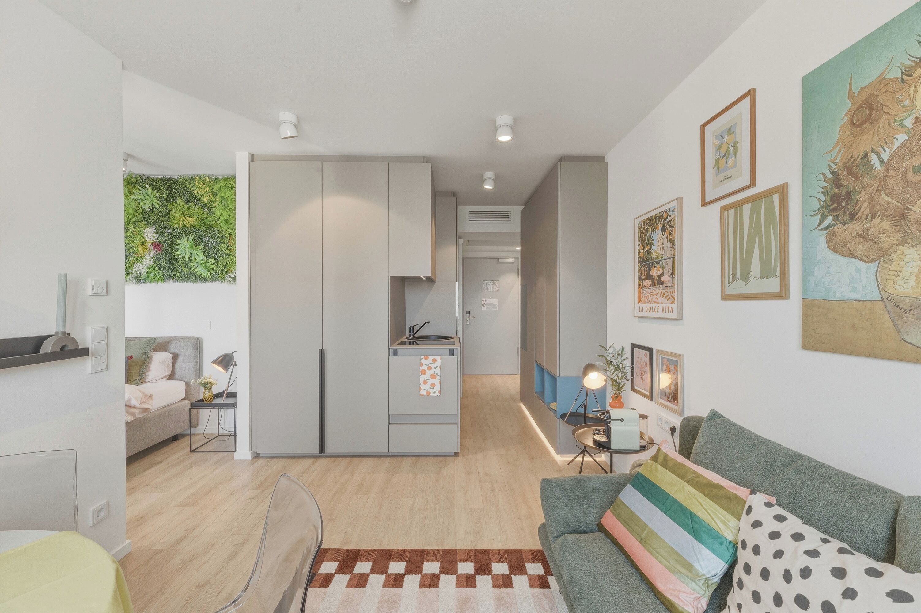 A modern living space with a kitchen, a dining area, and a sofa.