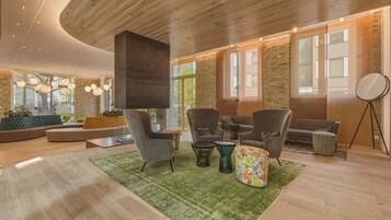 A modern interior with a wooden ceiling, large windows, and a mix of seating arrangements.
