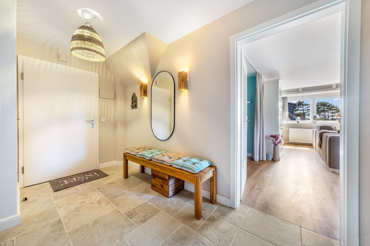 A modern hallway with a bench, a mirror, and a pendant light.