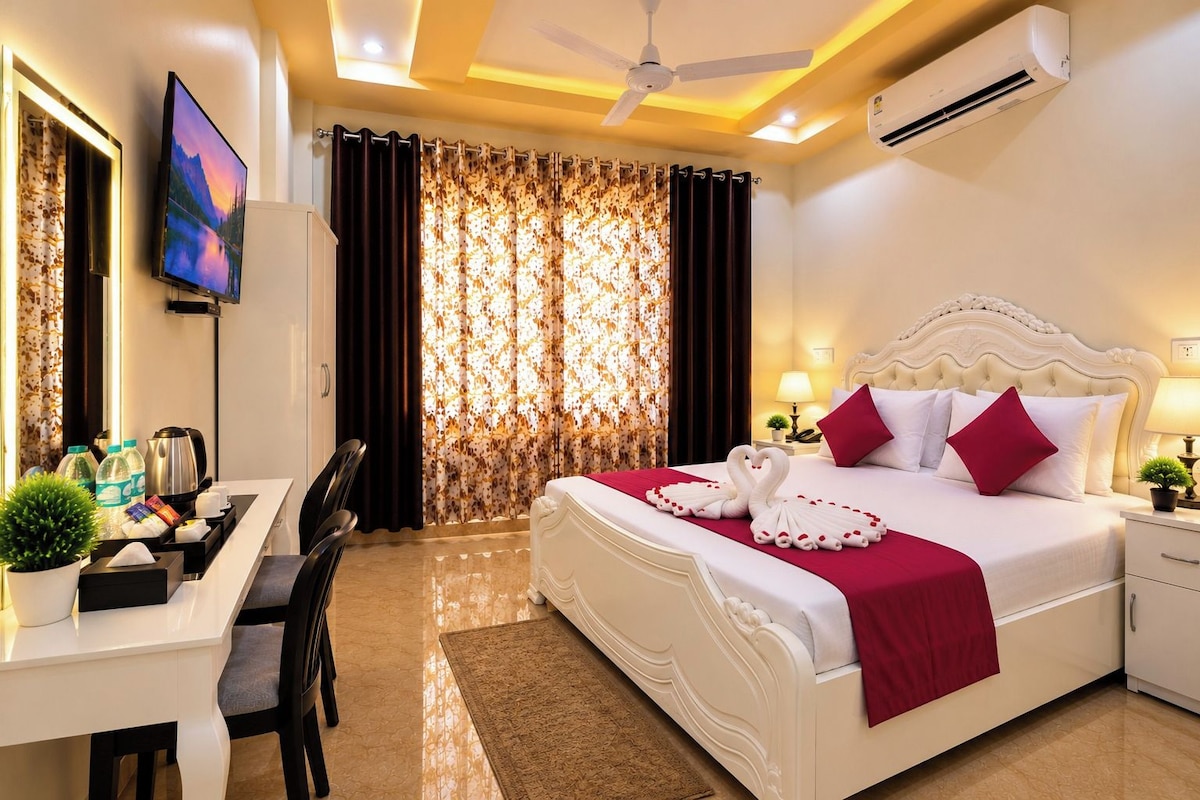 A hotel room with a bed, a desk, a television, and a window with curtains.