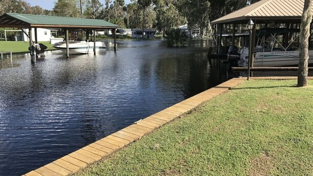 A calm water body with a wooden dock and a covered seating area. - Spacious 4BR Ocala National Forest Home with Private Hot Tub Near Salt Springs — Sleeps 8 (Salt Springs)
