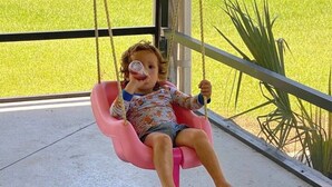 A child on a swing with a view of a green lawn. - Spacious 4BR Ocala National Forest Home with Private Hot Tub Near Salt Springs — Sleeps 8 (Salt Springs)