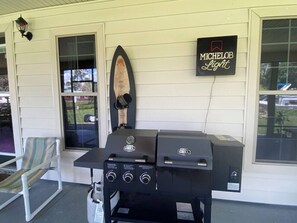 Ein Grill steht auf einer Veranda, mit einem Schild für Michelob Light.