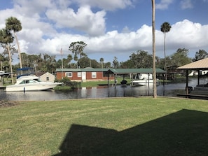 A waterfront property with a dock, a covered boat house, and a building with a green roof. - 4BR Salt Springs Retreat w/ Private Hot Tub (Salt Springs)