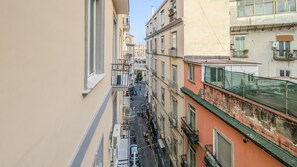 A narrow street between buildings with balconies, a clear sky, and a pedestrian walkway. - Residenza Edoardo - In the Heart of Naples (Napoli)