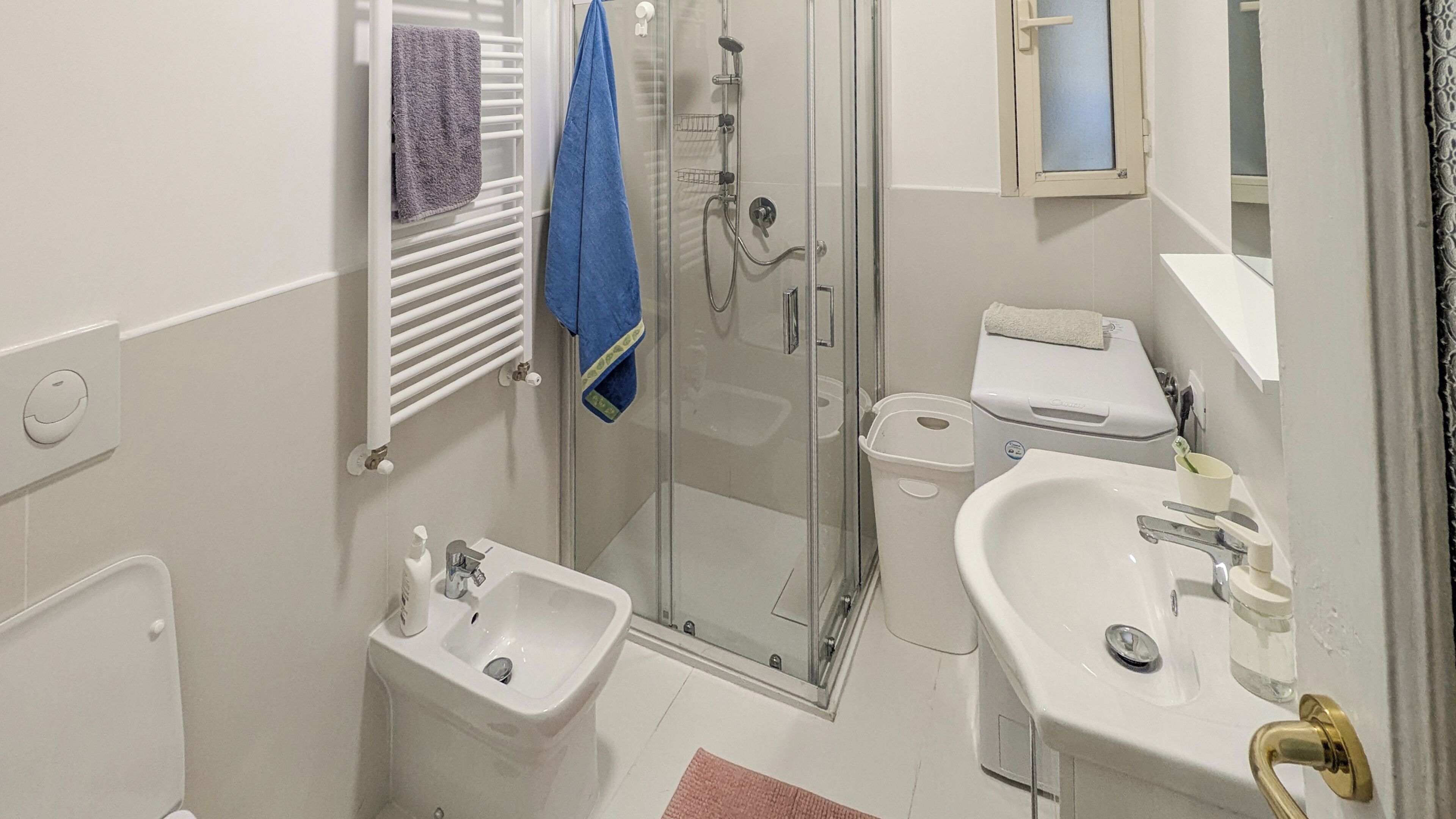 Une salle de bain avec une douche à parois de verre, un lavabo et des toilettes.