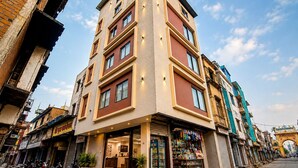Un edificio de varios pisos con una tienda en la planta baja y una entrada visible.