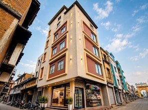 Un edificio de varios pisos con una tienda en la planta baja y una entrada visible.