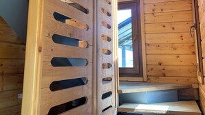 A wooden staircase with a view of the sky through a window.
