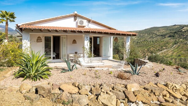 A single-story house with a tiled roof, a covered patio, and a view of a hilly landscape. - Holiday Home 'Paradise in Andalusia' with Mountain View, Wi-Fi and Air Conditioning (Tolox)