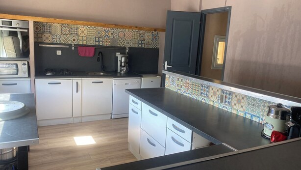 Cozinha compacta com micro-ondas, cafeteira e pia.