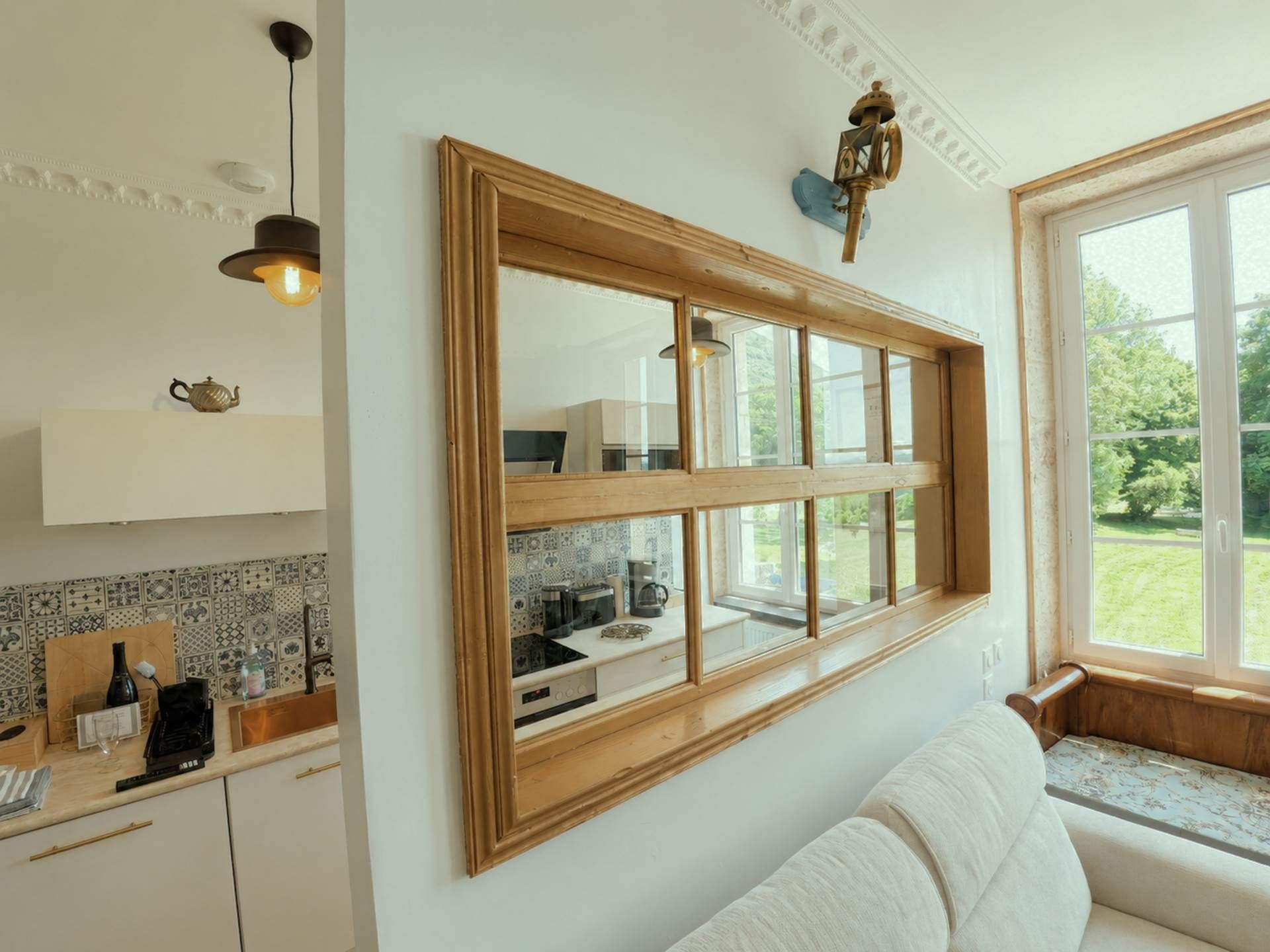 A modern kitchen with a large window, a built-in oven, and a white countertop.