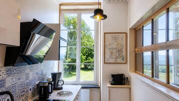 Una cocina con un ventanal grande, un mapa en la pared y una cafetera.