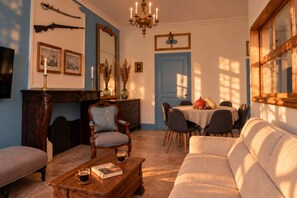 A traditional living room with a fireplace, a dining area, and a sofa.
