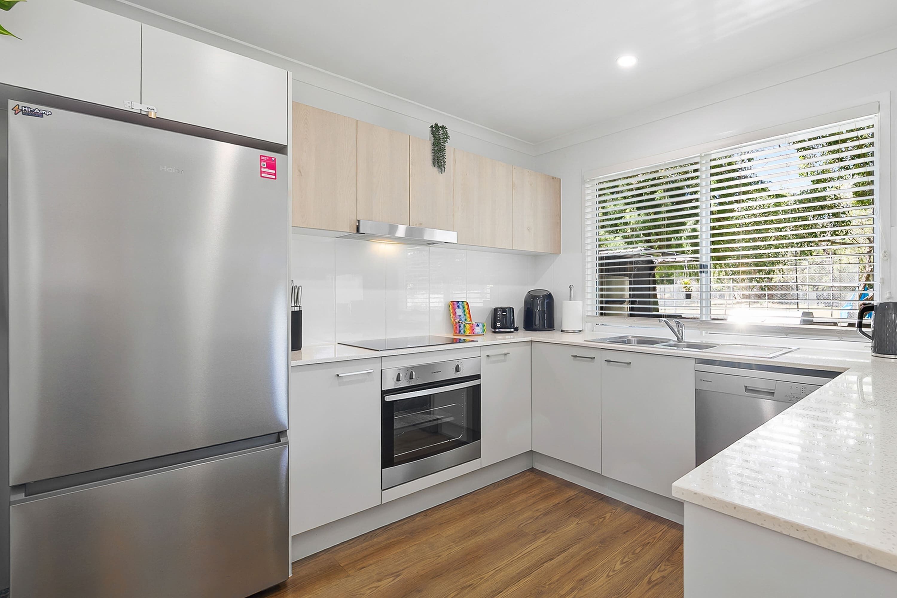 A modern kitchen with a stainless steel refrigerator, a built-in oven, and a dishwasher.