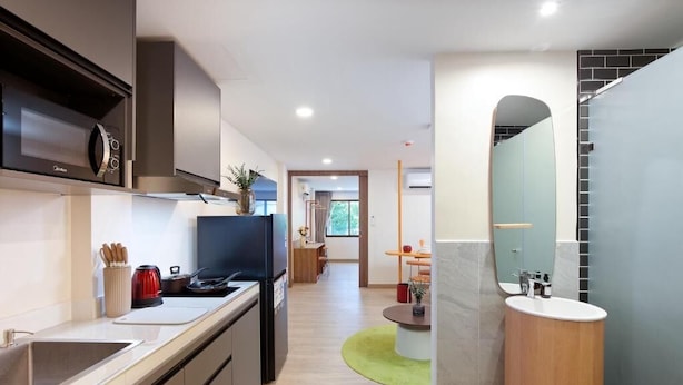 Una cocina moderna con microondas integrado, cafetera y pileta.