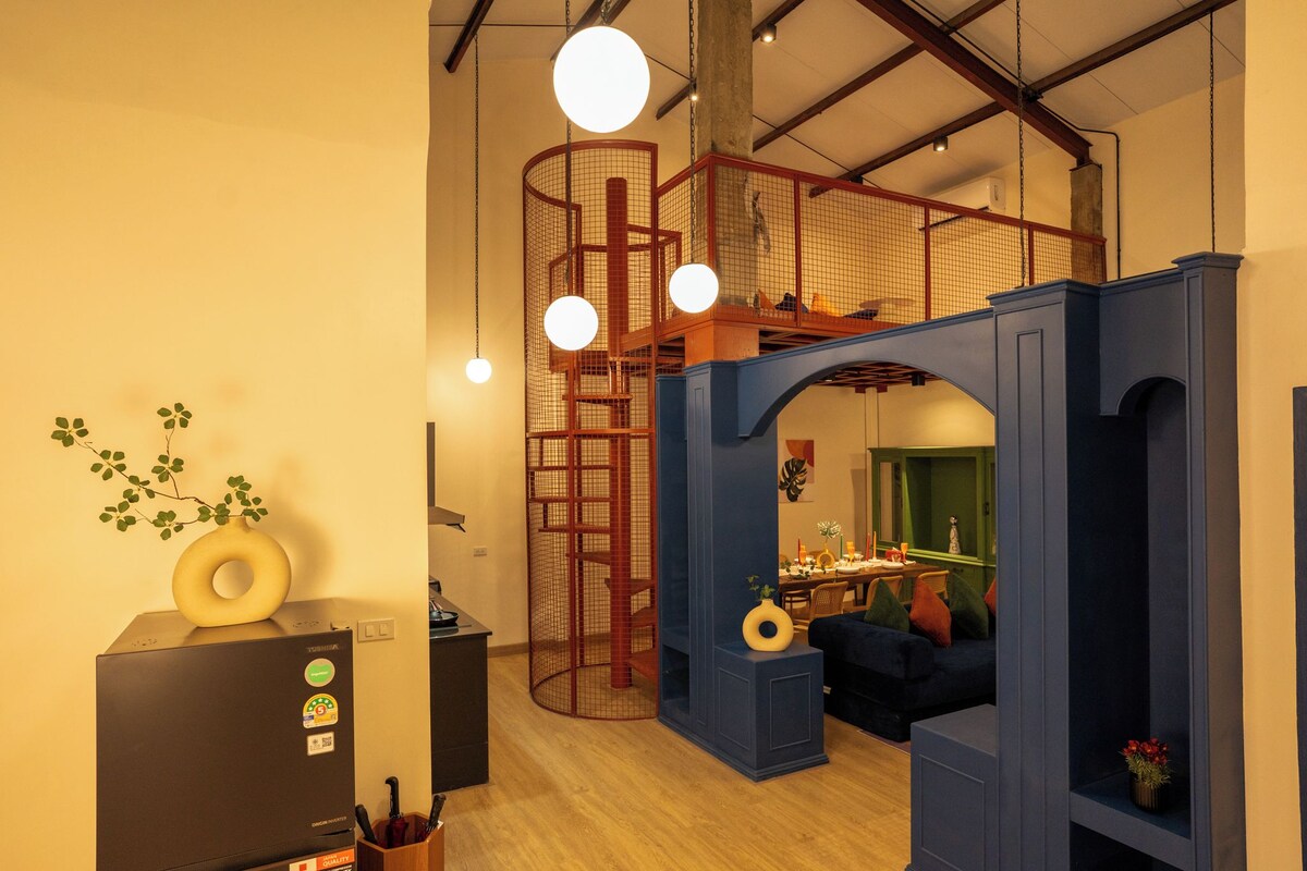 Um interior moderno com um mezanino, área de refeições e cozinha.