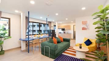 A modern living space with a dining area, kitchen, and seating area.