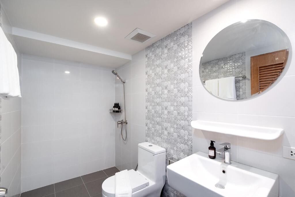 Une salle de bain moderne équipée de toilettes, d’un lavabo et d’une douche.