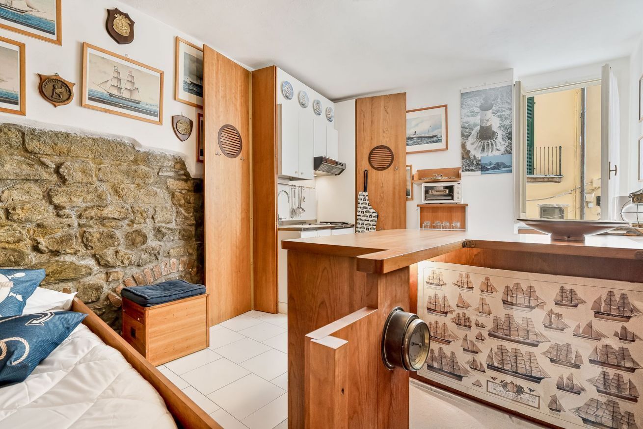 A room with a stone wall, wooden furniture, and maritime-themed decor.
