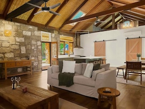 A spacious living area with a high ceiling, stone walls, and a cozy seating arrangement. - Highwoods Estate - A unique destination in the heart of Wine Country (Pokolbin)