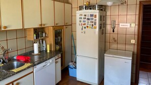 A compact kitchen with a dishwasher, a refrigerator, and a small countertop.