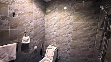 Un bagno con il water, una doccia e un portasciugamani.