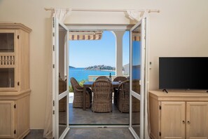 A room with a view of the sea, wicker furniture, and a television. - Fantastic 4-bedroom house with AC in Sevid na moru (Sevid na moru)