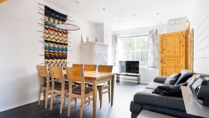 A modern living space with a dining area, a sofa, and a TV. - Alpine Kajo D4 by Aavalevi (Kittilä)