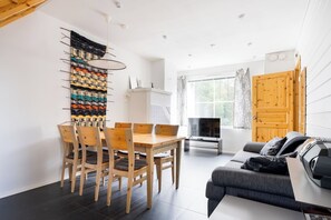 A modern living space with a dining area, a sofa, and a TV. - Alpine Kajo D4 by Aavalevi (Kittilä)
