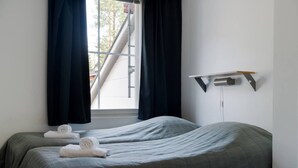 A hotel room with two beds, a window with curtains, a wall-mounted shelf, and a view of a staircase outside. - Alpine Kajo D4 by Aavalevi (Kittilä)
