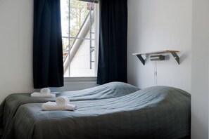 A hotel room with two beds, a window with curtains, a wall-mounted shelf, and a view of a staircase outside. - Alpine Kajo D4 by Aavalevi (Kittilä)