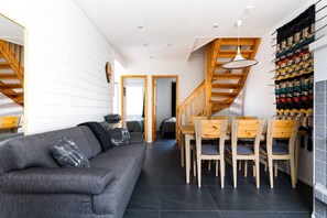 A modern interior with a grey sofa, wooden dining table, and chairs. - Alpine Kajo D4 by Aavalevi (Kittilä)