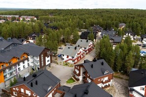 Ein Wohngebiet mit mehreren Häusern, von denen einige Balkone haben, umgeben von dichtem Wald.