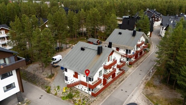 A residential area with multiple two-story houses, each with a distinct red and white color scheme, and a central road. - Alpine Kajo D4 by Aavalevi (Kittilä)