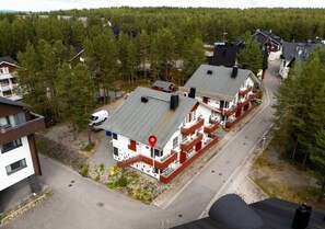 A residential area with multiple two-story houses, each with a distinct red and white color scheme, and a central road. - Alpine Kajo D4 by Aavalevi (Kittilä)