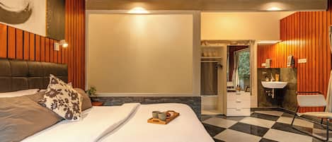 Un dormitorio moderno con una cama grande, una mesita de noche, una lámpara de pared y vistas al baño.