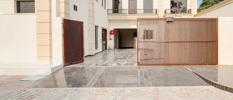 A gated entrance to a building with a tiled pathway leading to a door.