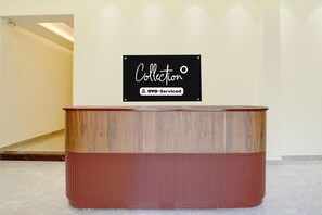 Un comptoir d’accueil avec une pancarte indiquant « Collection OYO – Services inclus ».