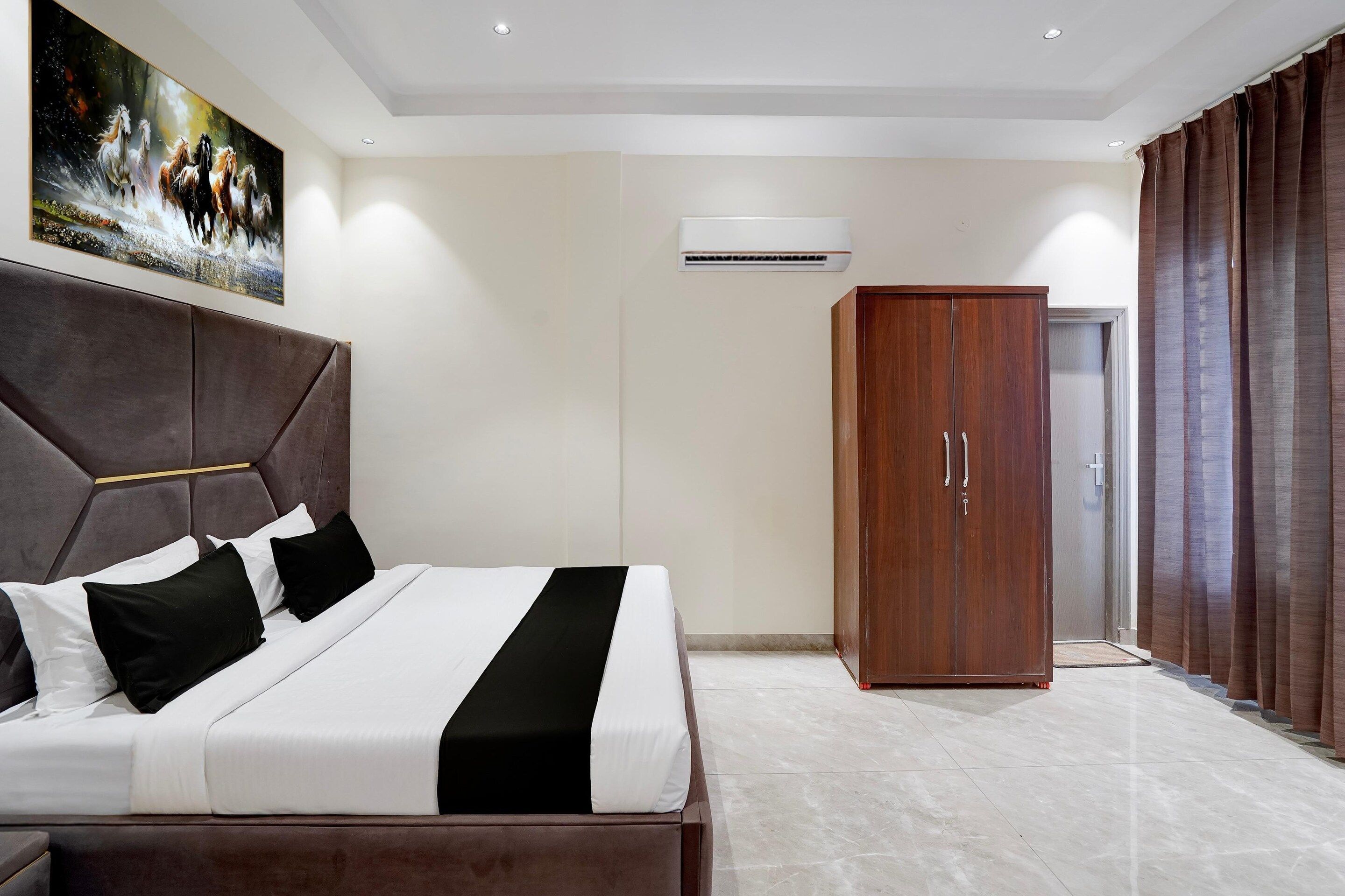 Ein modernes Schlafzimmer mit einem großen Bett, einem Kleiderschrank und einem Bild an der Wand.