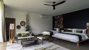 Un dormitorio moderno con una cama grande, un sofá, una mesa de centro y un ventilador de techo.