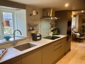 A modern kitchen with a built-in sink, a toaster, and a wine rack. - Ullswater retreat near Helvellyn-Bath & EV charger (Glenridding)