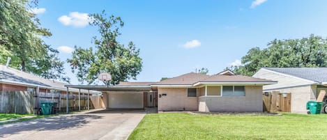 A residential property with a garage, a covered patio, and a well-maintained lawn.
