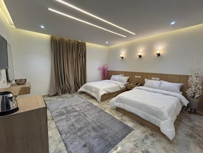A hotel room with two beds, a flat-screen TV, a coffee maker, and a decorative plant. - Nakhil Pyramids Resort (Giza)